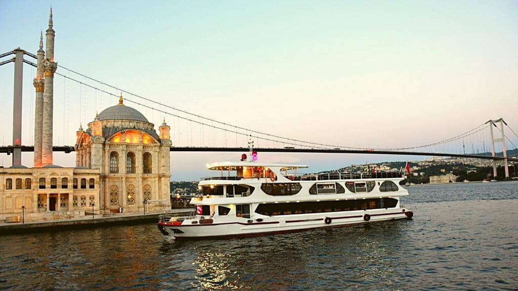 Bosphorus dinner cruise boat passing Ortaköy Mosque at sunset in Istanbul 🚤🕌