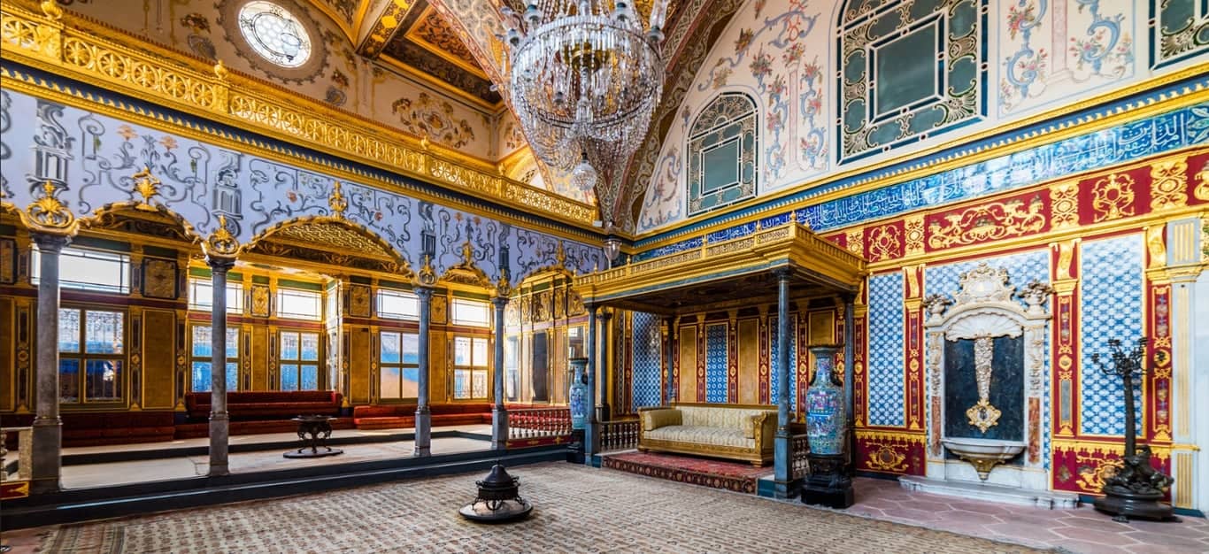 Ornate Ottoman salon with tiles and wood seating inside a historic palace