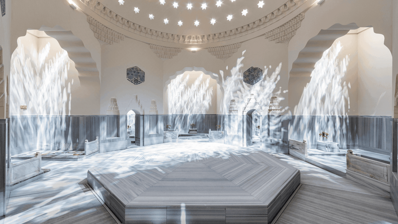 Central marble göbektaşı in bright hammam chamber with cascading water effect 🫧