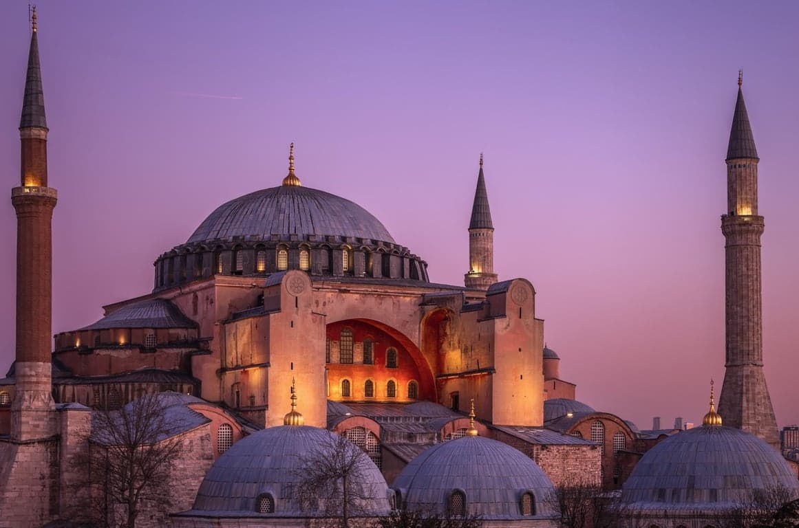 Hagia Sophia at dusk with softly lit domes and skyline behind